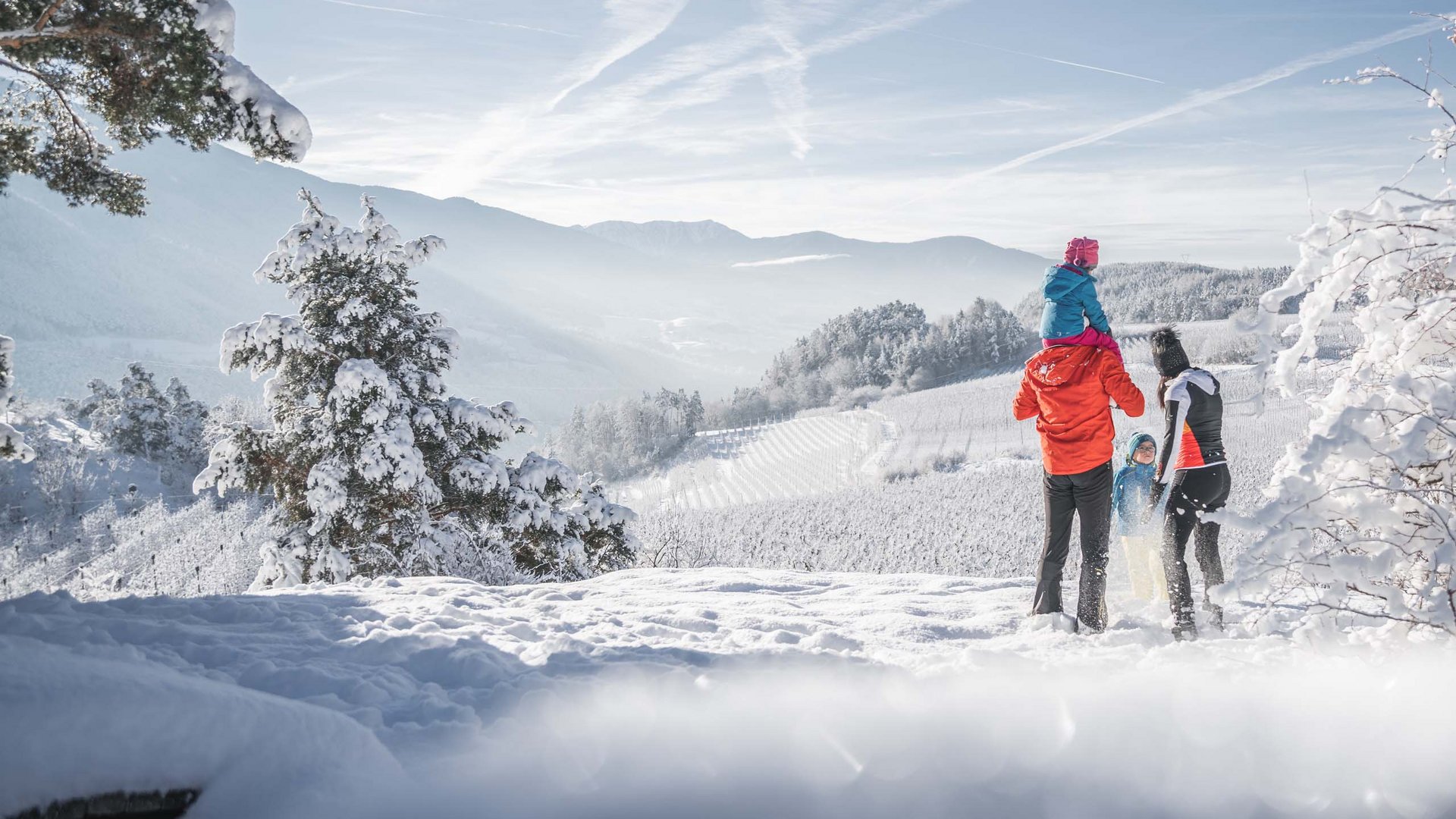 Ihr Wanderhotel in Südtirol für Frühling, Sommer und Herbst Familie steht im Schnee mit schneebedeckten Bergen im Hintergrund