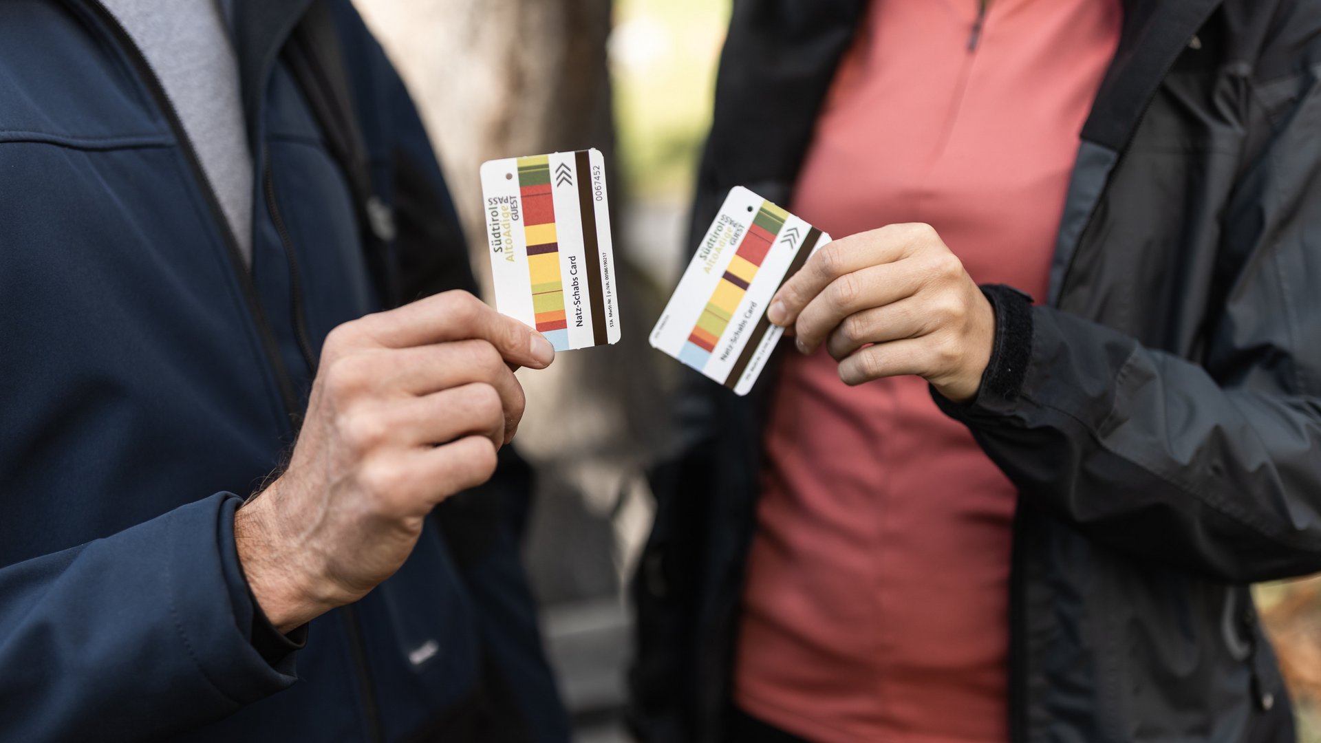 Zwei Personen zeigen Südtirol Alto Adige Guestcards in der Hand