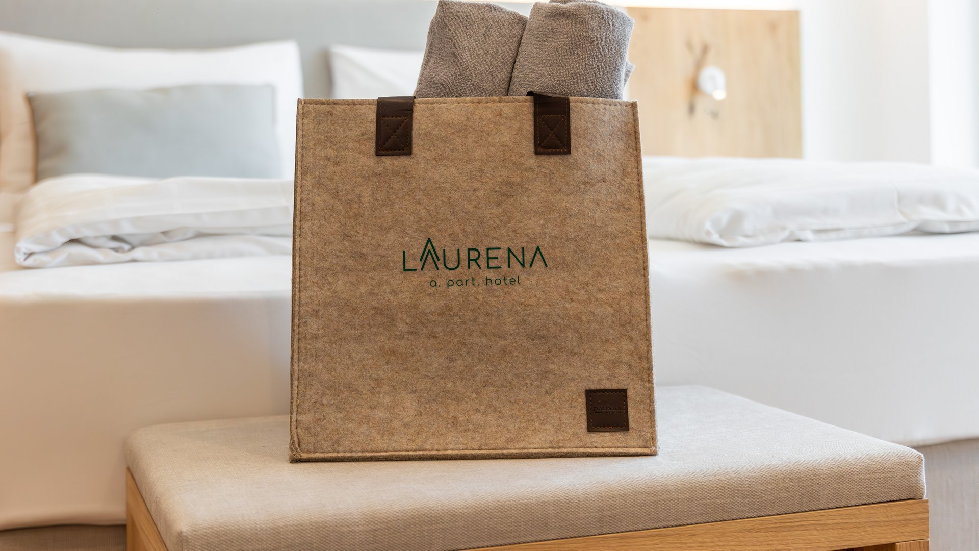 Aparthotel Laurena: Inklusivleistungen Fühltasche mit zwei Handtüchern auf einem Hocker vor einem Bett im Hotelzimmer